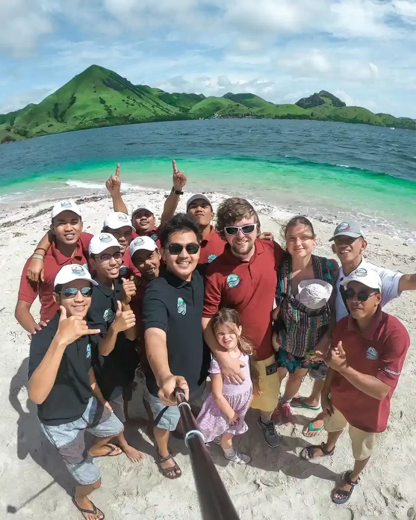 Group photo of Indonesian yacht crew and guests together on a beach